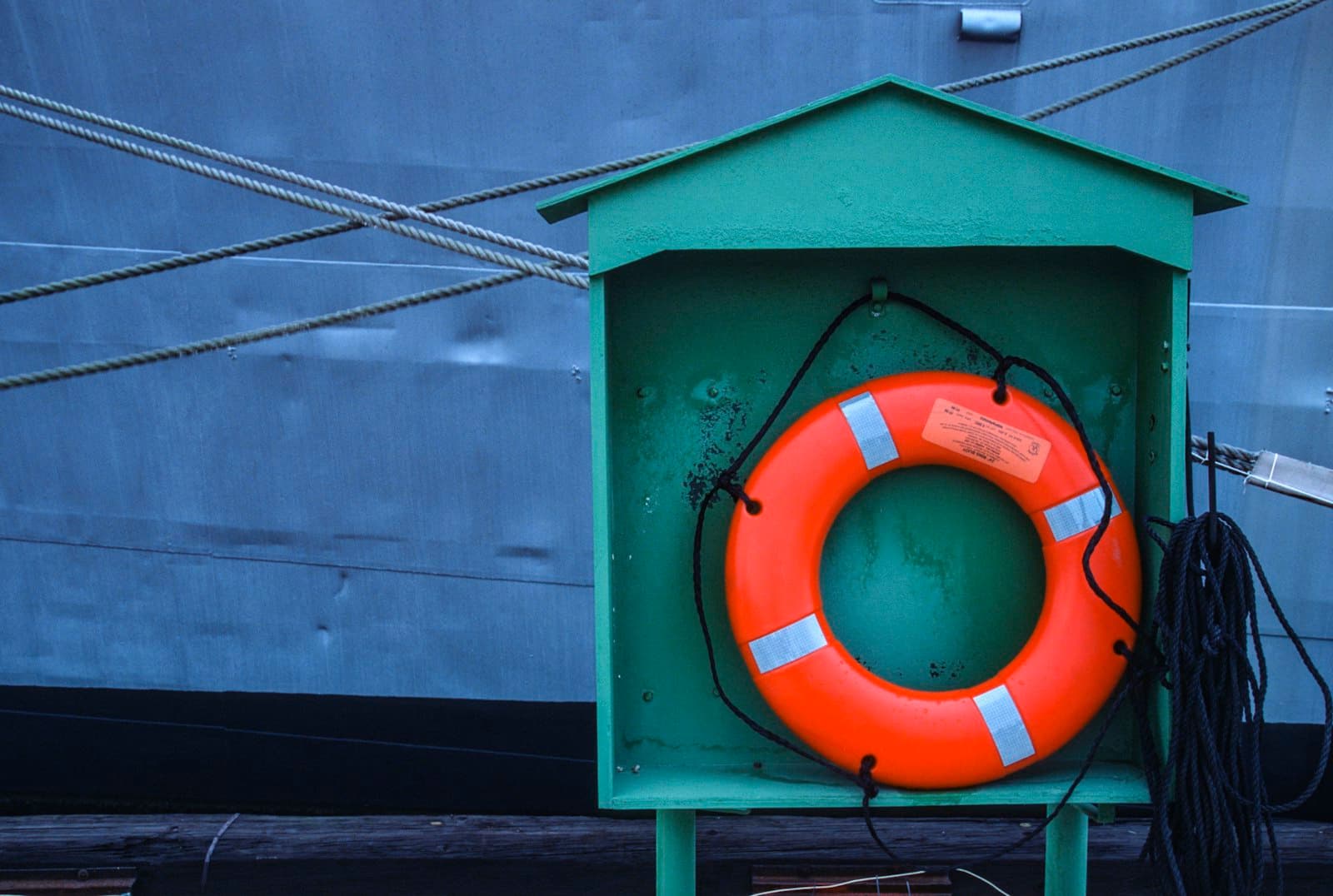 An orange life ring mounted in its stowage box aboard a ship